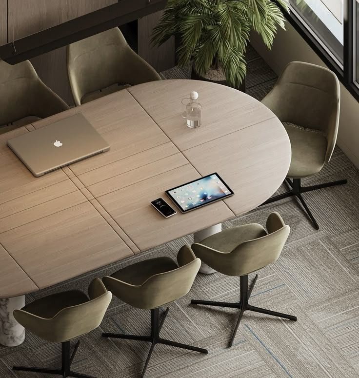 Table de réunion ovale entourée de fauteuils vert olive